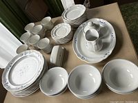 Full set layout showing seven dinner plates, seven dessert plates, seven bowls, seven cups, six saucers, butter dish with lid, creamer, sugar bowl, and platter.