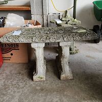 Full side view of concrete bench showing decorative top and support pedestals