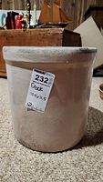 Photo of ceramic crock showing full front and side, stamped marking visible