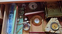 Overview of all included clocks and wristwatches including Howard Miller desk clock, vintage watches, and two additional clocks with various faces and frames.