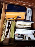 Photo showing multiple pen sets in original boxes including Waterman, Sheaffer, Cross, Merangue with letter opener