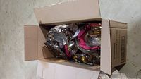 Box filled with assorted silver plated serveware items showing a collection of plates, trays, and other tableware pieces.