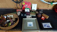 Photo showing a basket of toy cars and figurines, framed prints, wood barrel, origami, and Boyds Bear figurine on table