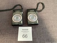 Front view of two Canon PowerShot ELPH 160 cameras showing lenses and wrist straps