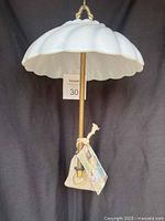 Full view of hanging porcelain bird feeder with seed bag and tag