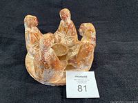 Full view of terracotta candle holder with four figures and central cup