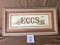 Front view of framed "EggS" print showing artwork, mat and frame