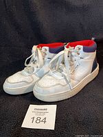 Three-quarter view of both sneakers showing uppers, laces, side Nautica branding