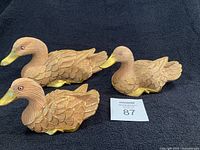 Three carved wooden duck figurines displayed together