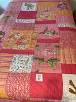 Full view of patchwork quilt on bed with lot sticker