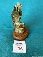 Front view of brass eagle on wood base
