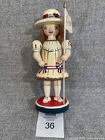 Front view of wooden girl figurine on round base