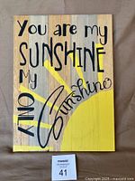 Front view of complete wooden sign showing design and text