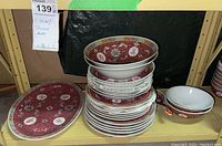 Stack of plates and bowls showing matching red and white Asian design with Chinese characters
