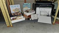 Overview of Elna machine, carrying case, guidebook, boxes of thread and notions