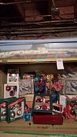 Vintage Christmas decorations displayed on a storage shelf including boxed ornaments, loose decorations, and Christmas tree topper.