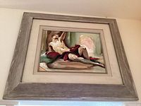 Framed watercolor painting of a reclining man with red drapery, rustic wood frame with wide mat, signature partially visible ending in 'gent'.
