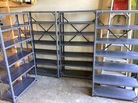Four grey metal storage shelves positioned side by side showing overall condition and size.