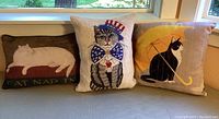 Three cat-themed throw pillows arranged side by side, showing all three designs in one image.