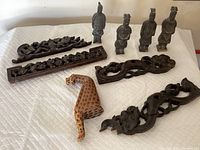 Full overview of all Chinese soldier figurines and wood carved pieces arranged on white cloth