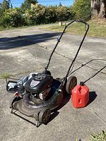 Full shot of Craftsman lawn mower on concrete with gas can beside it