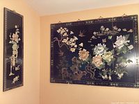Smaller and larger wall art panels hung on a corner wall.