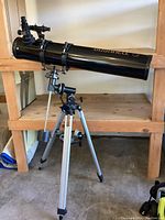 Full view of telescope mounted on adjustable aluminum tripod with metal equatorial mount and counterweight.