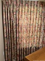 Full view of floral pleated curtains covering a wall section.