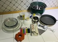 Overview of entire baking set showing mixing bowls, pie plates, cake decorating items, funnel and other tools