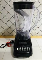 Full view of the Proctor Silex blender showing clear blending jar with black lid and handle, placed on a white surface.