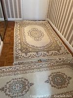 View of the smaller carpet showing its pattern and missing tassels on one end.