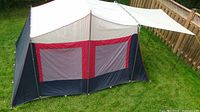Side view of Coleman Oasis tent showing large screened windows, color design and attached awning.