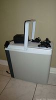 Front view of Koolatron electric cooler and warmer with carrying handle and power cords on top