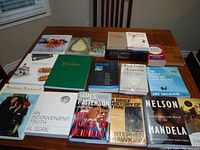 Photo showing a table with 19 books laid out, spanning topics from art to politics and science, used condition.