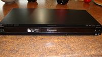 Front view of Panasonic DMP-BD65 Blu-ray disc player showing control buttons and logos.