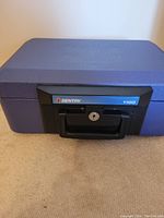 Blue SentrySafe 1100 fireproof safe chest with key lock and handle shown from top side.