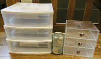Two 3-drawer organizers side by side with a soda can for size comparison. White plastic organizer with translucent drawers on the left and clear acrylic organizer with gold knobs on the right.