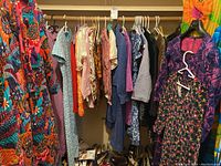 Closet rack with assorted garments hanging and shoes below