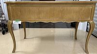 Front view of white oak desk showing scalloped apron and curved legs