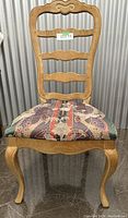 Front view of the white oak ladder-back chair showing four horizontal slats and patterned upholstered seat.