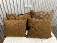 Set of four handmade pillows arranged together showing different textures and colors.