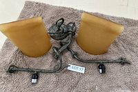 Two wrought iron wall sconces with amber tulip-shaped glass shades, each sconce holds two bulbs.