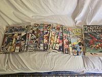 Photo showing an array of comic books spread out including Quasar, Amazing Spider-Man and Batman comics.