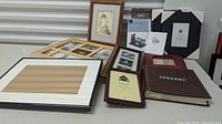 Overview of the assorted collection of empty frames showing various styles, colors, and sizes, including photo album and multi-photo collage frame.