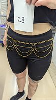 Model wearing the gold-tone chain belt around the waist showing fit and style