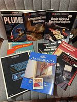 Photo showing the front covers of all 8 DIY books detailing plumbing, electrical wiring, basements, and repair topics.