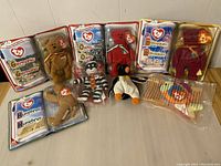 Seven McDonald's TY Beanie Babies, including Germania, Osito, Legend, and Millennium bears. Displayed in original plastic packaging or unopened bags.