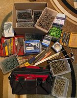 Full lot overview with all boxes of screws, toolbox, tape, drill bits, and small items arranged for display.