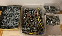 Overview photo of four containers filled with assorted screws and hardware.
