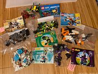 Five Lego sets with instruction booklets and parts in bags, including Mixels and City themes